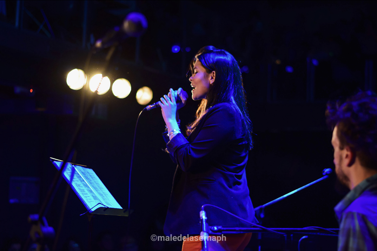 Cantante en vivo bajo luces violetas y azules